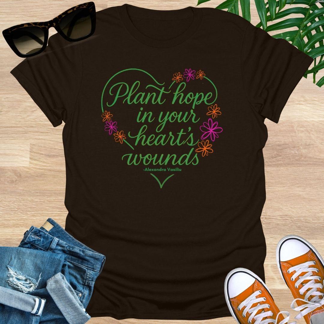 Dark Chocolate tee with a Floral heart and script “Plant hope in your heart’s wounds”, Alexandra Vasiliu, on a unisex tee.