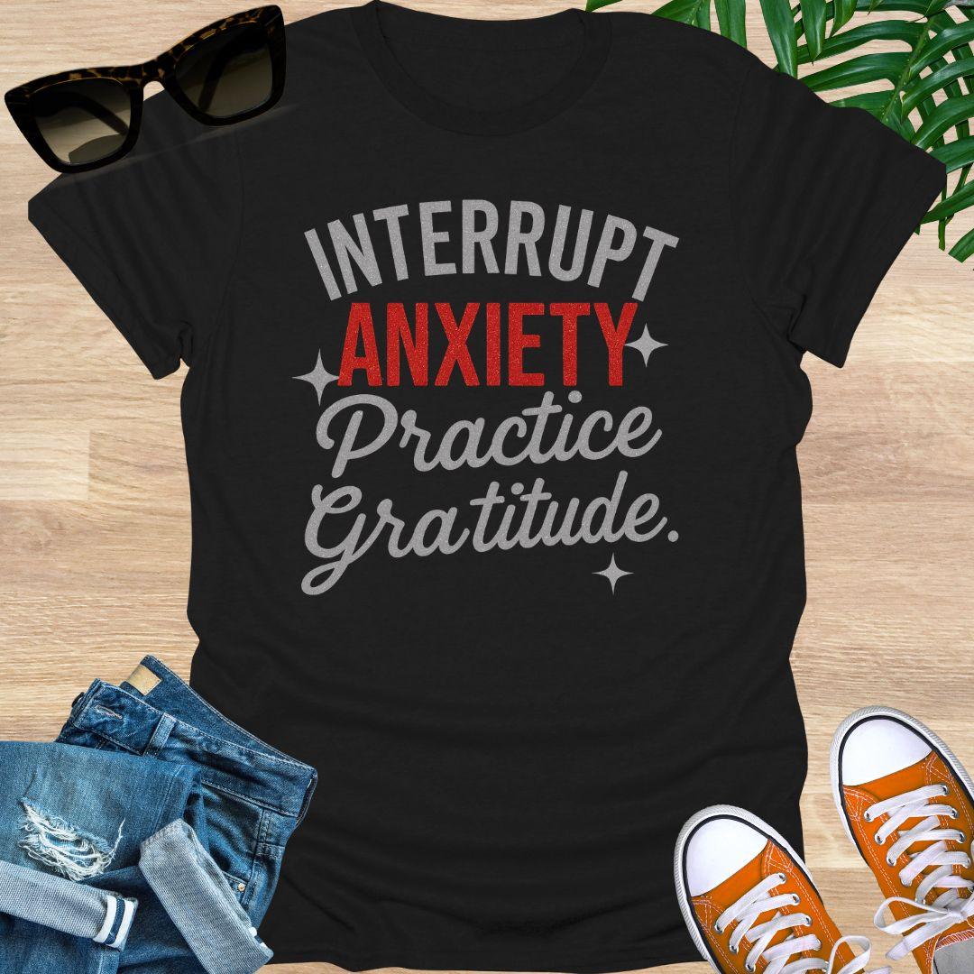 “Interrupt Anxiety, Practice Gratitude” sparkle text on a black unisex mindfulness tee