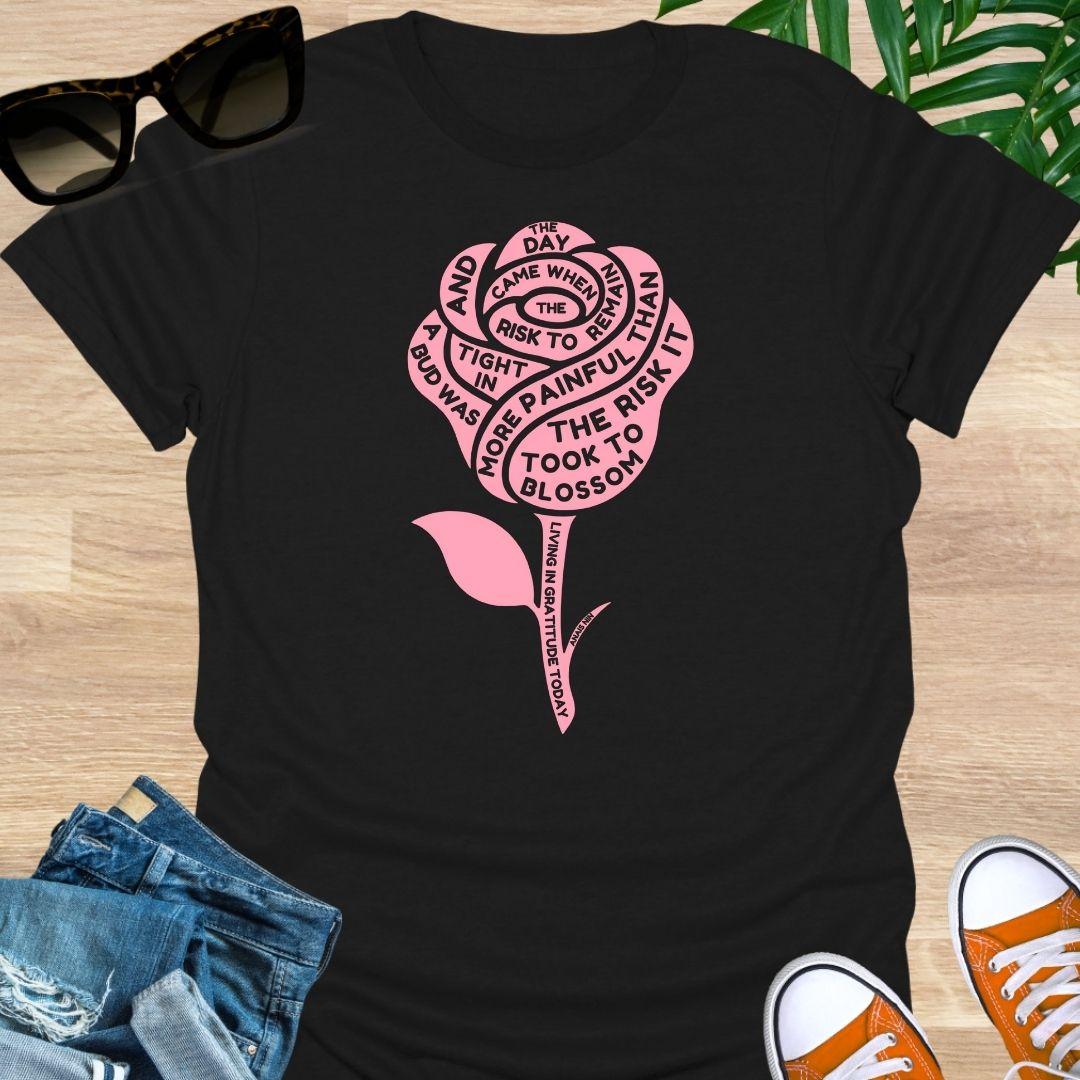 Pink rose with Anaïs Nin “Risk to Blossom” quote on empowerment and growth on a black unisex tee