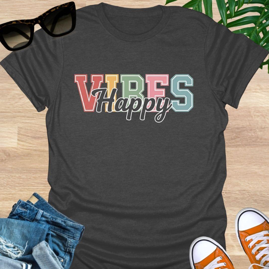 “Happy Vibes” in retro varsity letters with script overlay on a heather charcoal gray unisex tee.