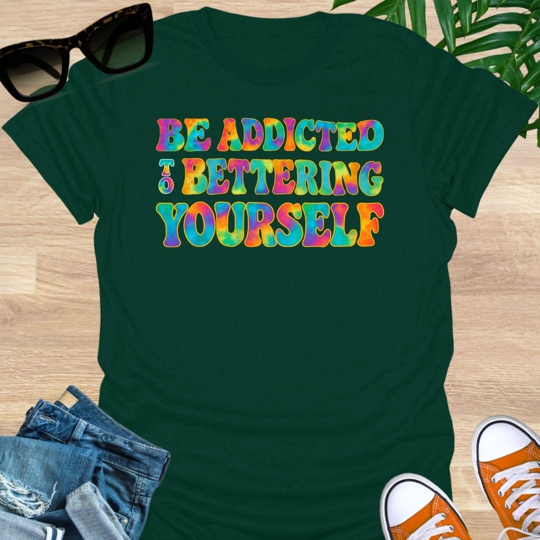Rainbow tie-dye “Be Addicted to Bettering Yourself” text on forest green unisex growth-mindset tee.