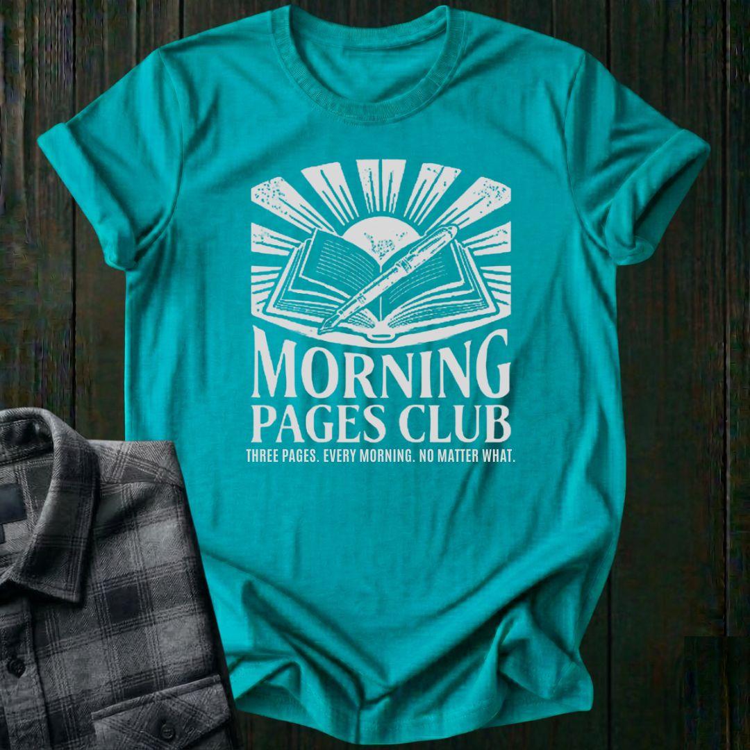 Vintage-style graphic featuring an open journal, pen, and sunrise above the words "Morning Pages Club" with the phrase "Three Pages. Every Morning. No Matter What." on a turquoise tee.