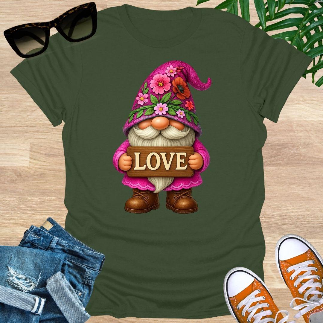Green t-shirt with a gnome holding a 'LOVE' sign on a wooden surface with sunglasses, jeans, and shoes.