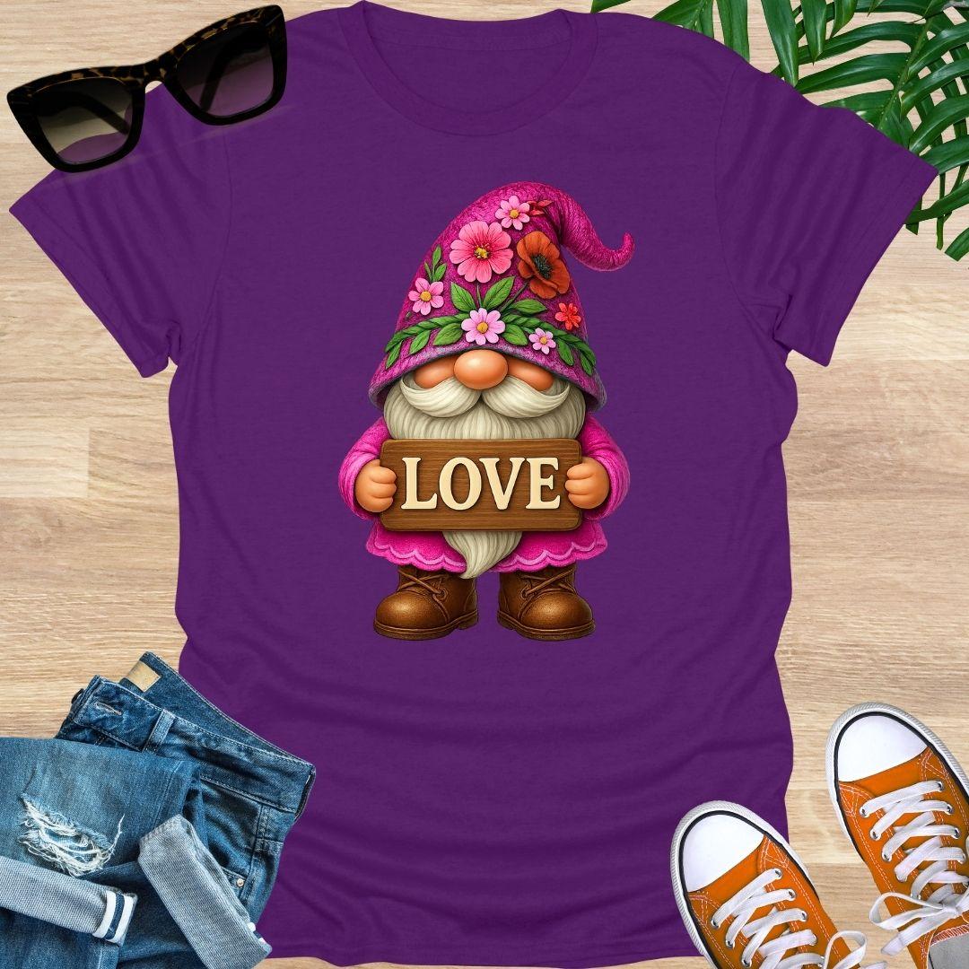 Purple t-shirt with a gnome holding a 'LOVE' sign on a wooden surface with sunglasses, jeans, and shoes.