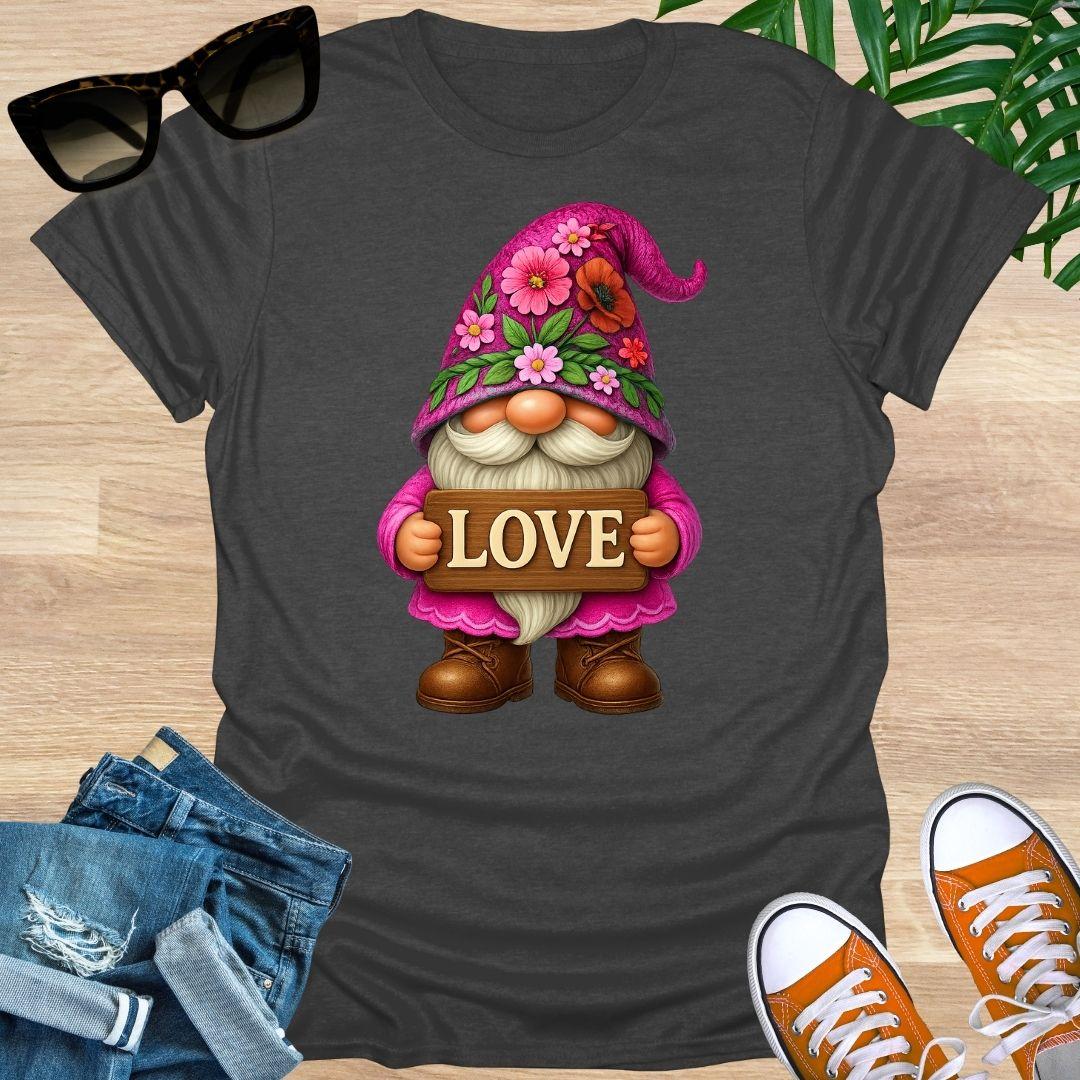 Black t-shirt with a cartoon gnome holding a 'LOVE' sign on a wooden surface with sunglasses, jeans, and shoes.