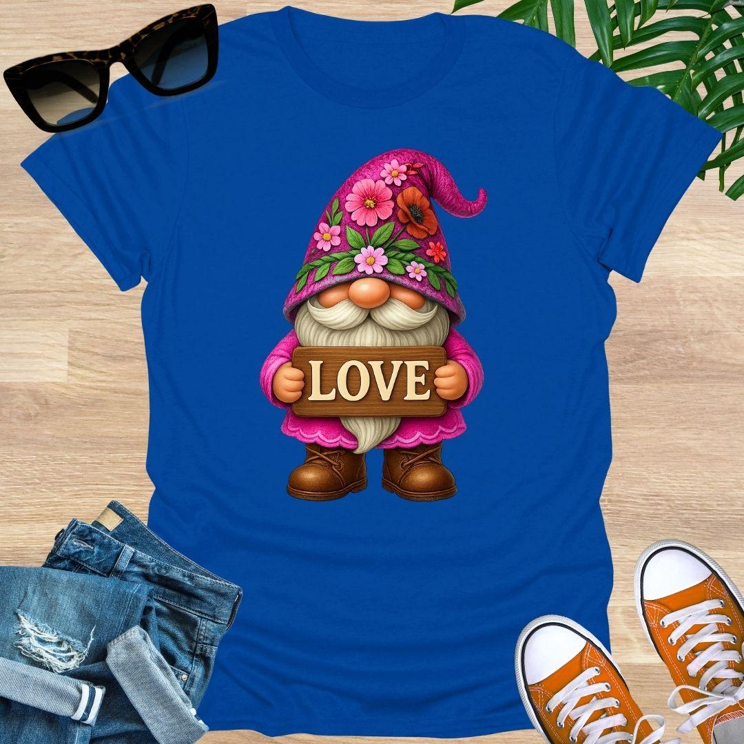 Blue t-shirt with a cartoon gnome holding a 'LOVE' sign on a wooden surface.