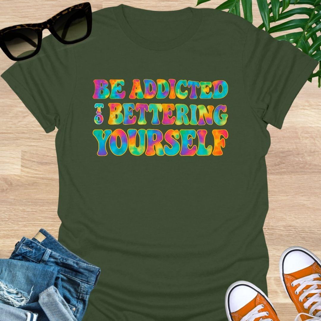 Rainbow tie-dye “Be Addicted to Bettering Yourself” text on military green unisex growth-mindset tee.