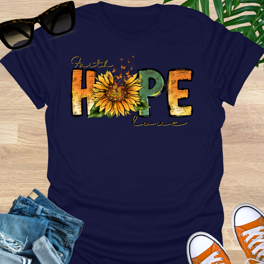 Navy blue t-shirt featuring sunflowers and monarch butterflies between the words "Faith, Hope, Love" on a unisex graphic tee.