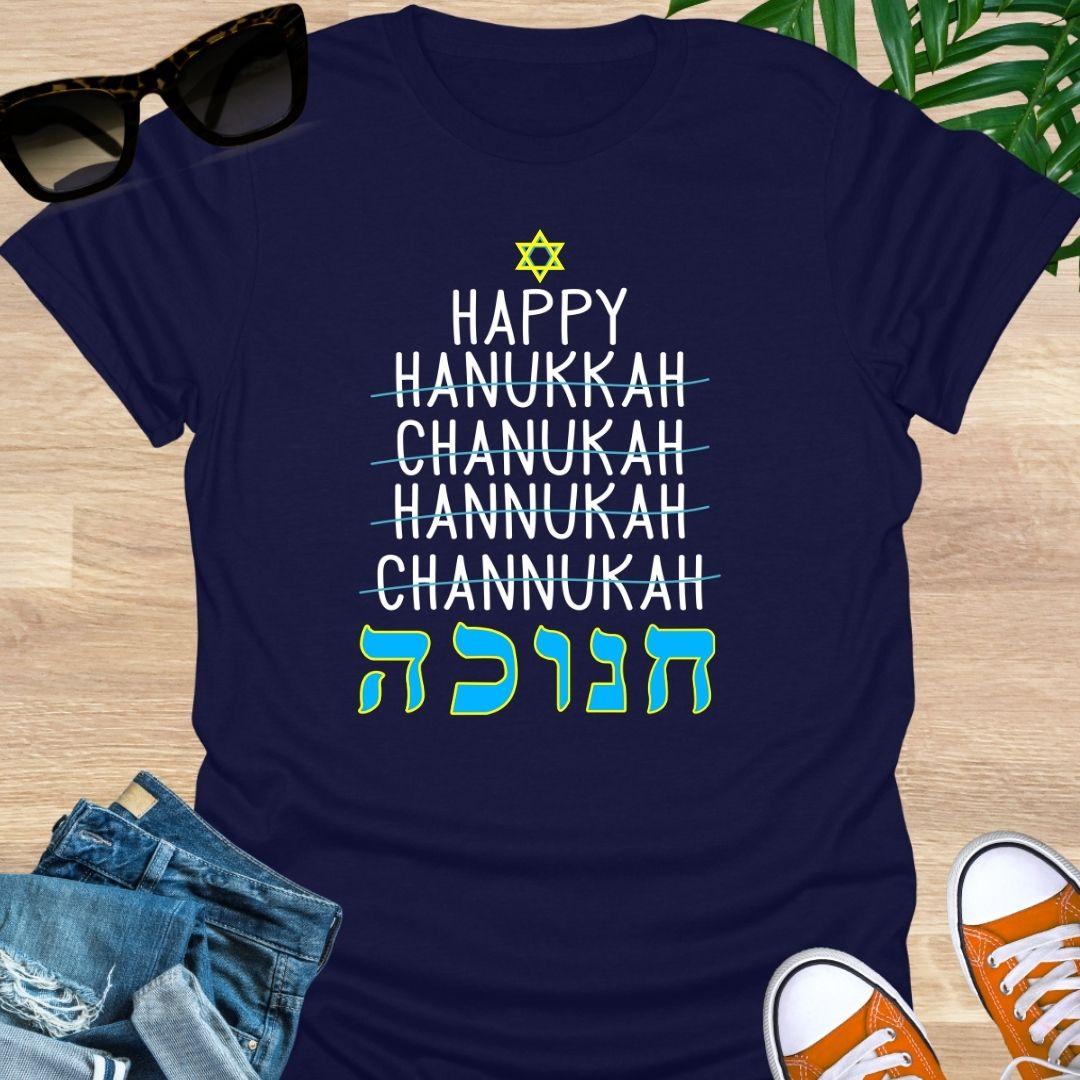 Happy Hanukkah with crossed-out spellings and large Hebrew letters plus a Star of David on a navy unisex tee.