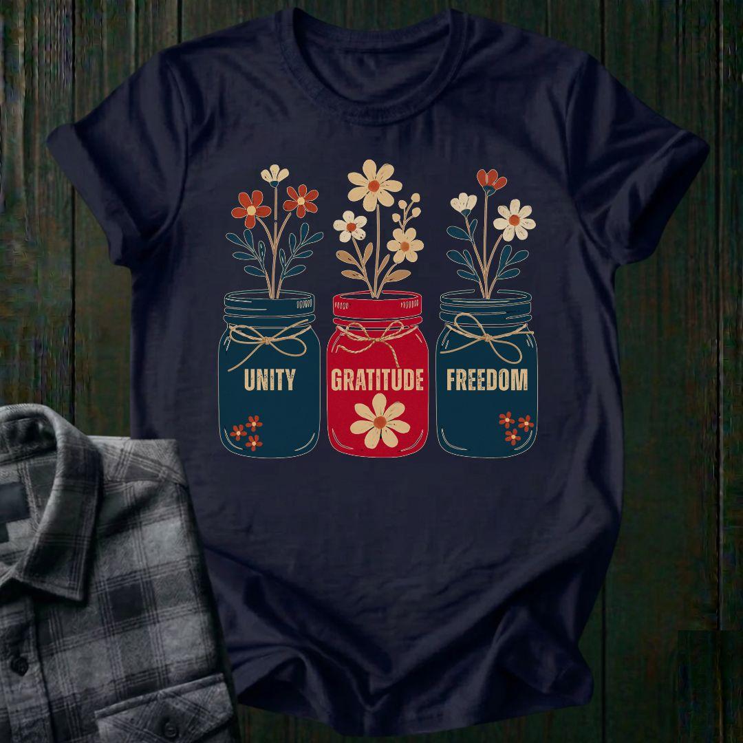 Navy blue t-shirt with floral jars and text on a wooden surface