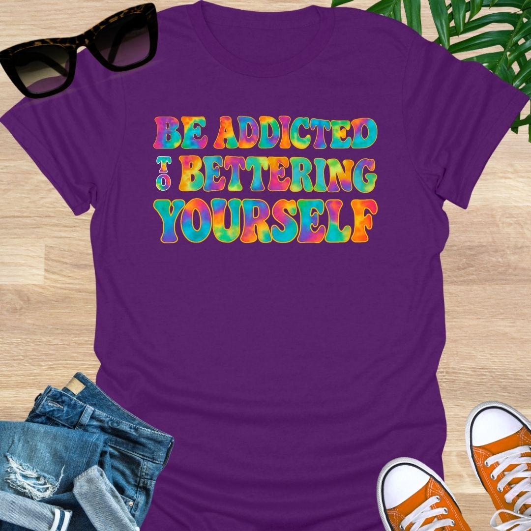 Rainbow tie-dye “Be Addicted to Bettering Yourself” text on purple unisex growth-mindset tee.