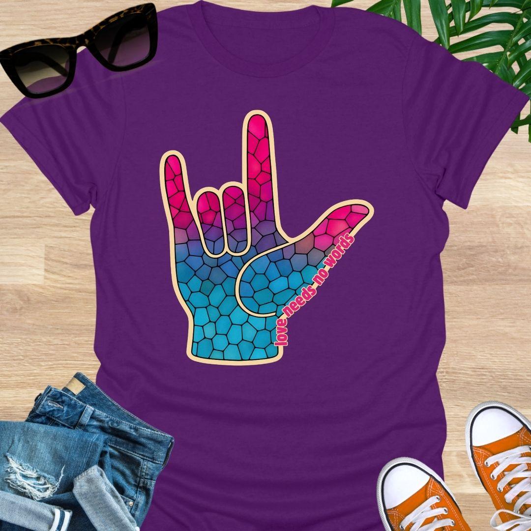 ASL I Love You hand in pink-to-blue mosaic with the words “love needs no words” on a purple unisex tee.