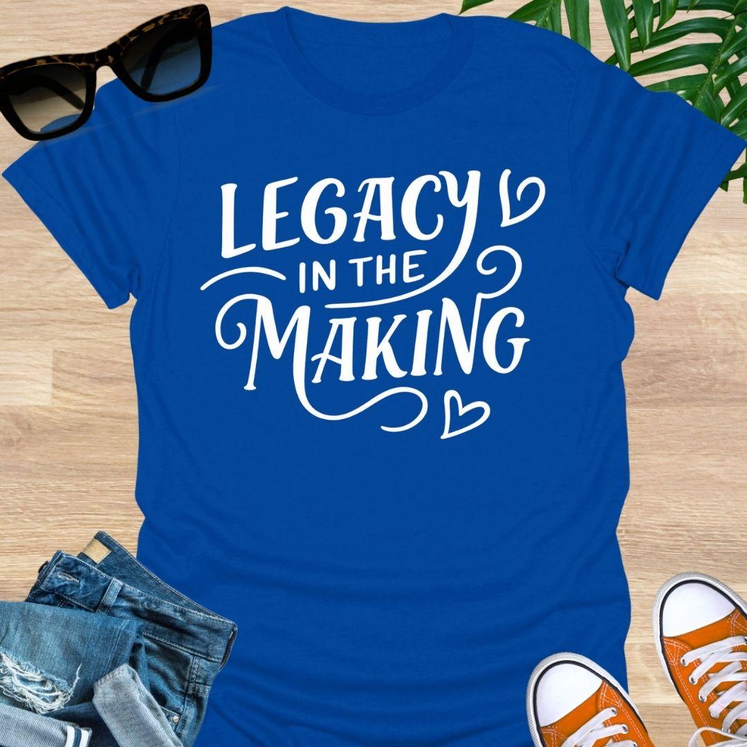 White script “Legacy in the Making” with heart flourishes on a blue motivational blue graphic tee.