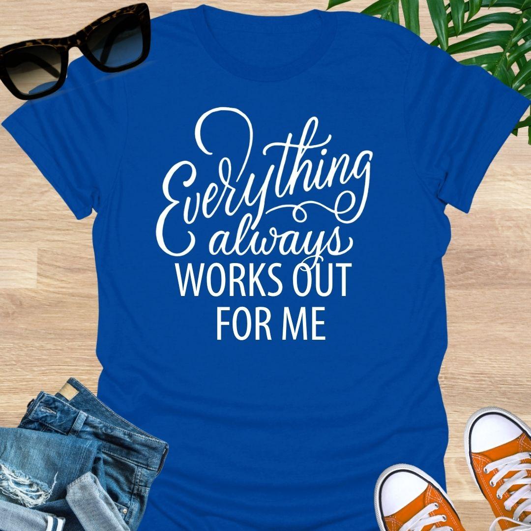 White script text reads “Everything always works out for me” on a blue unisex affirmation tee.