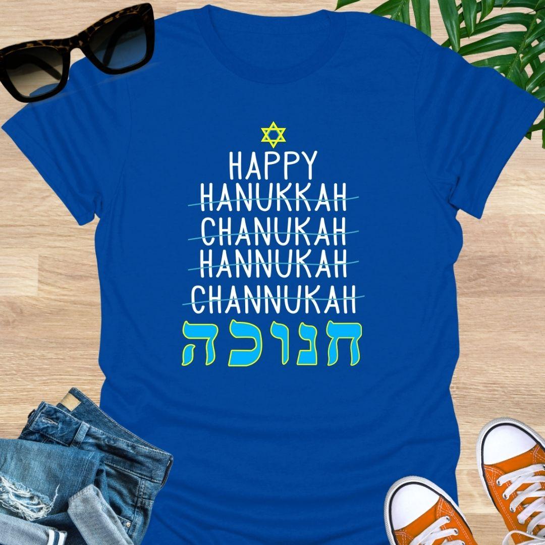 Happy Hanukkah with crossed-out spellings and large Hebrew letters plus a Star of David on a royal blue unisex tee.