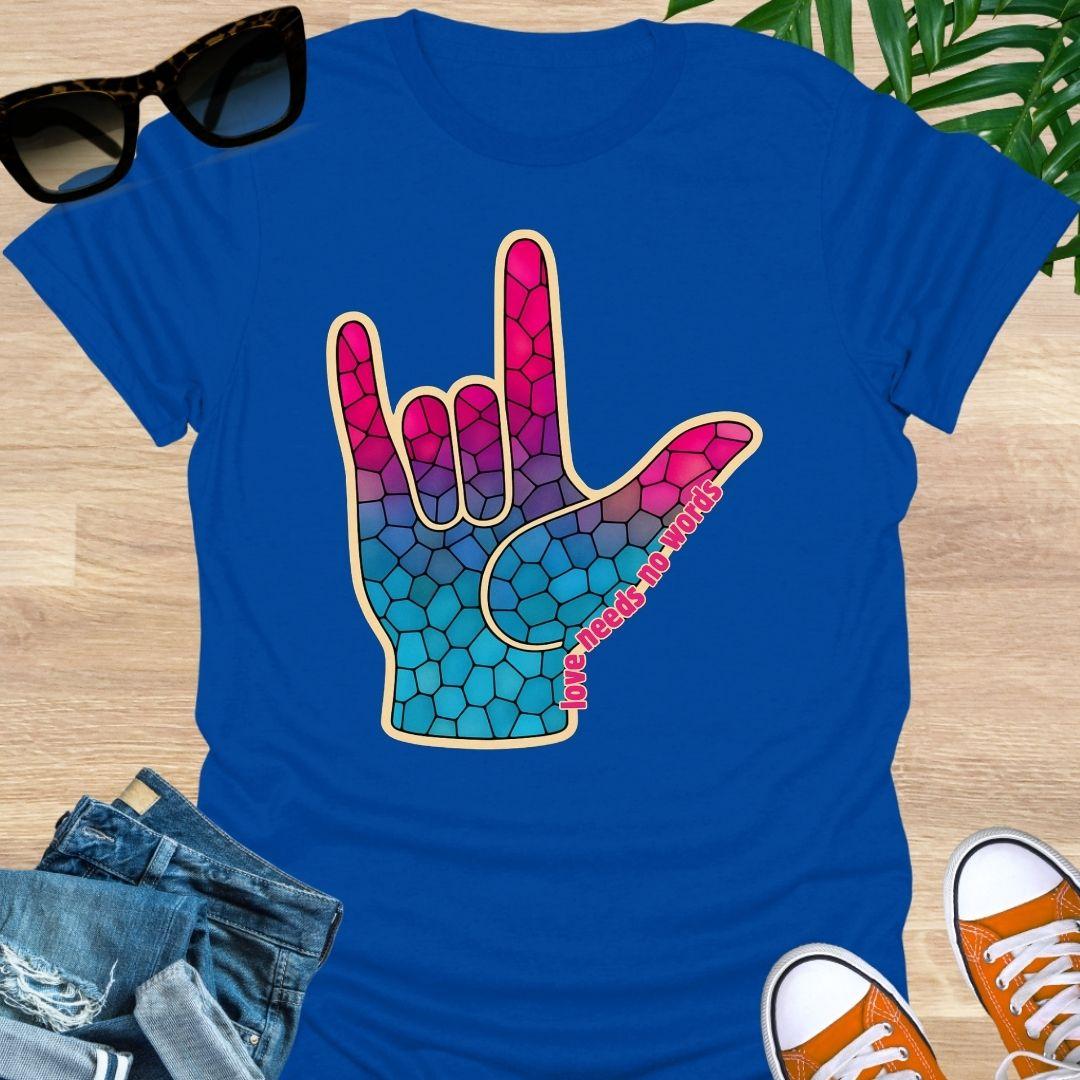 ASL I Love You hand in pink-to-blue mosaic with the words “love needs no words” on a royal blue unisex tee.