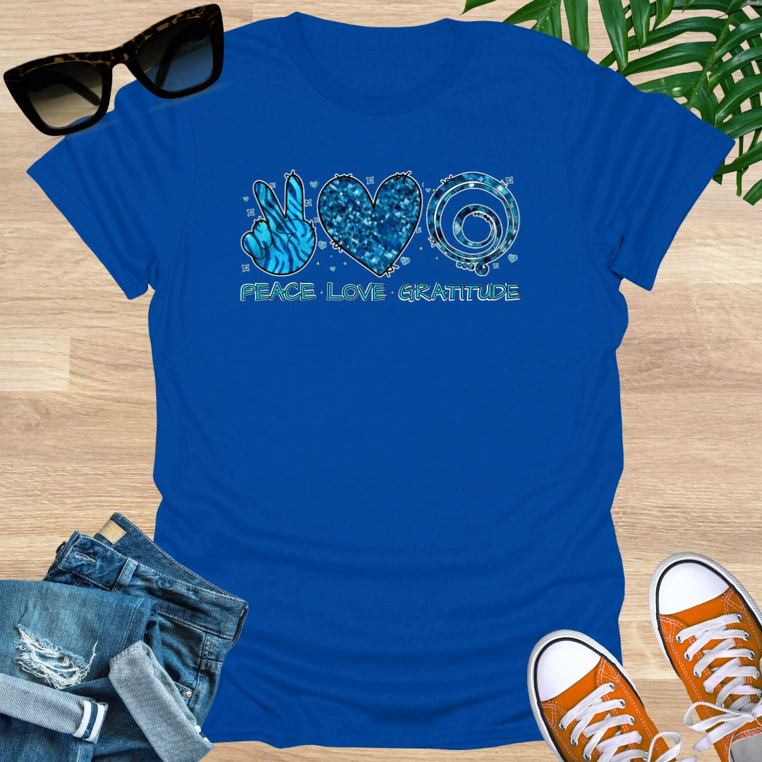 Royal blue unisex T-shirt with peace sign, heart, and spiral text reading “Peace • Love • Gratitude.”