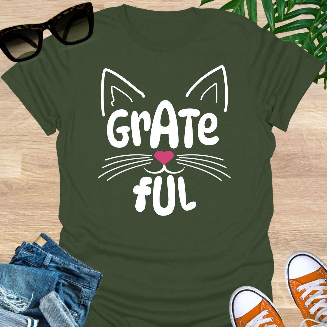 Military Green unisex graphic t-shirt with cat ears, whiskers, and a pink heart nose forming the word GRATEFUL