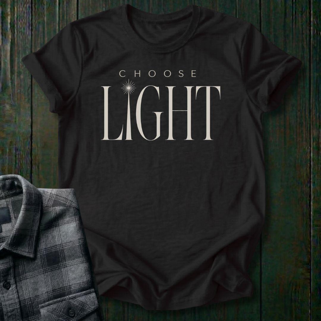 Elegant minimalist typography design featuring the phrase "Choose Light" with a radiant sunbeam replacing the letter I in "Light" on a black tee