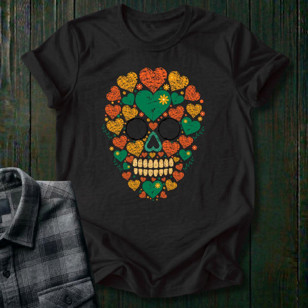 Distressed floral skull graphic made from colorful hearts, flowers, and botanical elements in green, orange, and yellow vintage-style artwork on a black tee