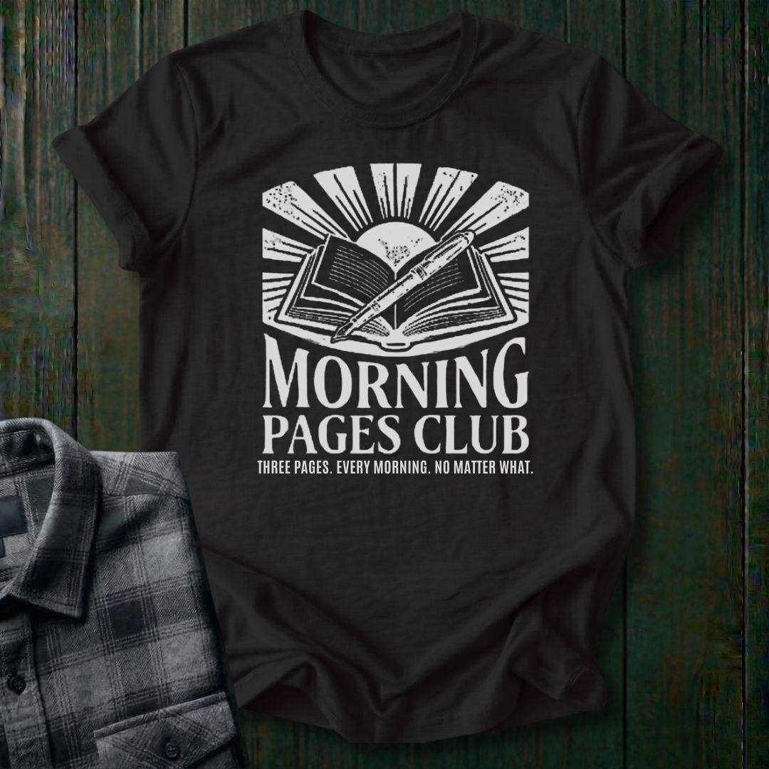 Vintage-style graphic featuring an open journal, pen, and sunrise above the words "Morning Pages Club" with the phrase "Three Pages. Every Morning. No Matter What." on a black tee. 