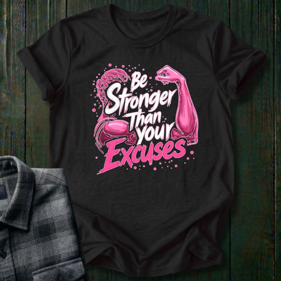Black t-shirt with pink graphic and text 'Be Stronger Than Your Excuses' on a wooden surface.