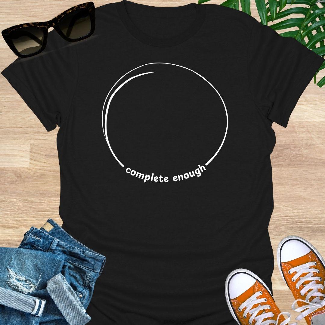 Minimal incomplete circle line art with the words “complete enough” on a black unisex t-shirt