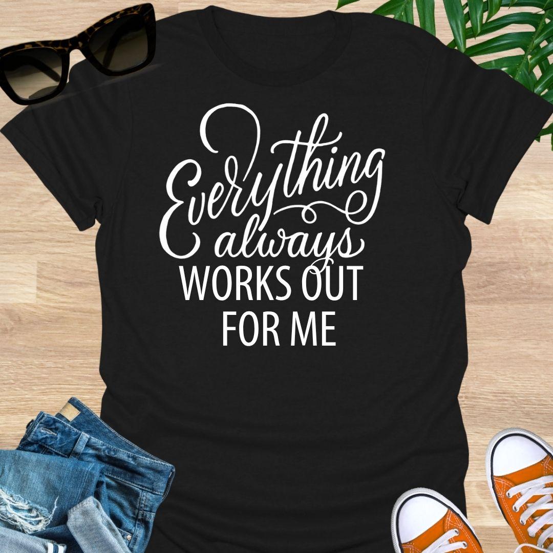 White script text reads “Everything always works out for me” on a black unisex affirmation tee.