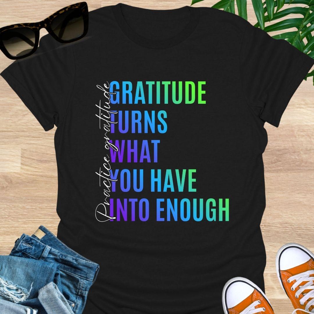Gradient text tee reading “Gratitude turns what you have into enough” with script “practice gratitude" on a black unisex tee