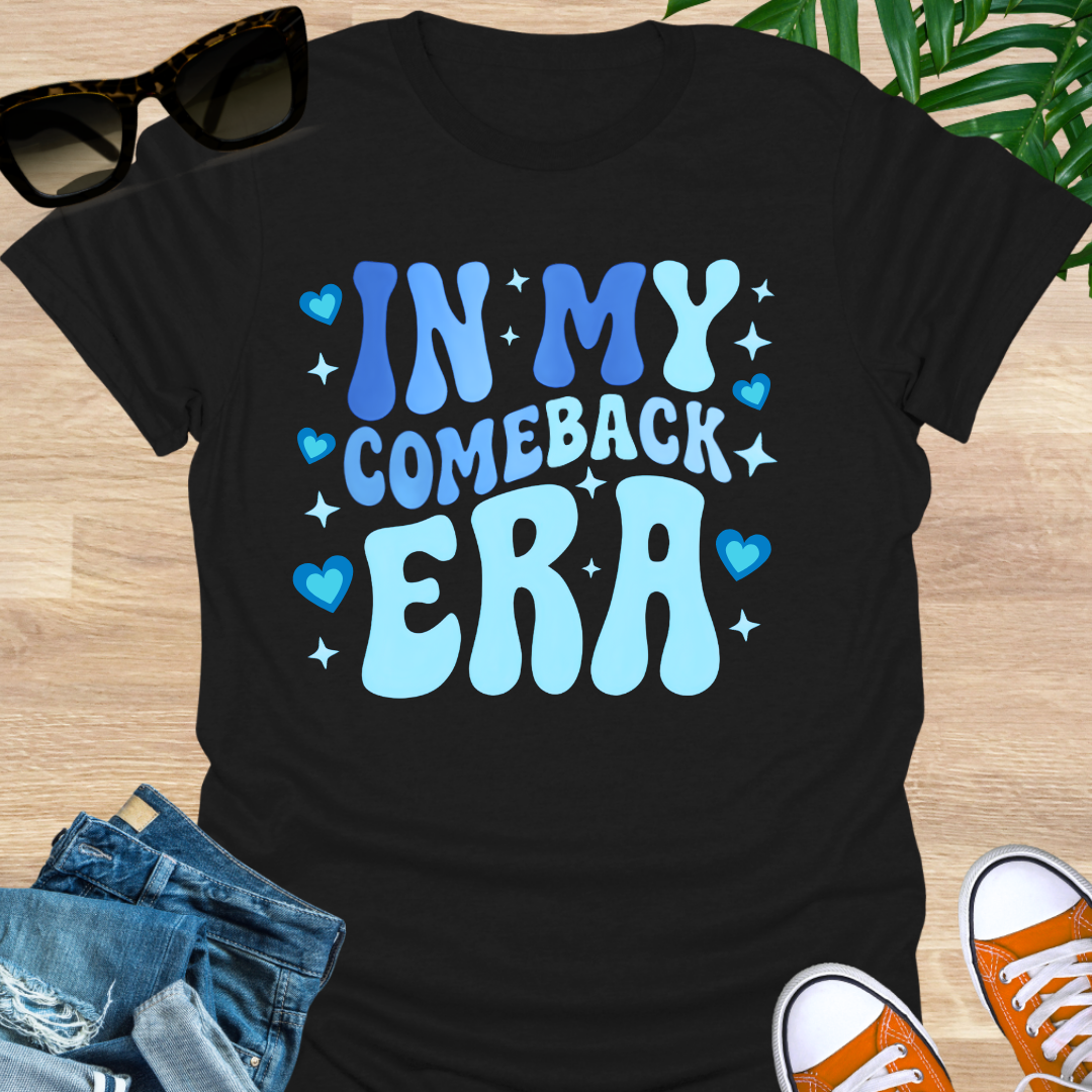 Light-blue groovy text “In My Comeback Era” with hearts and star accents on a black motivational graphic tee.