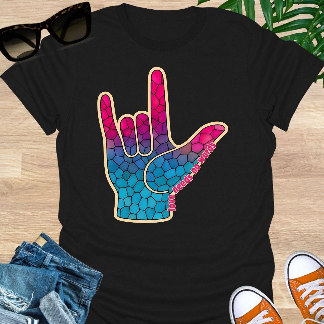 ASL I Love You hand in pink-to-blue mosaic with the words “love needs no words” on a black unisex tee.