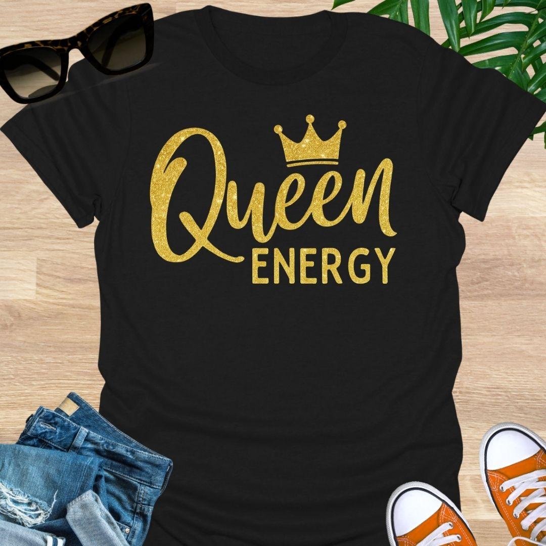 Gold glitter script “Queen Energy” with a crown on a black empowerment graphic tee.