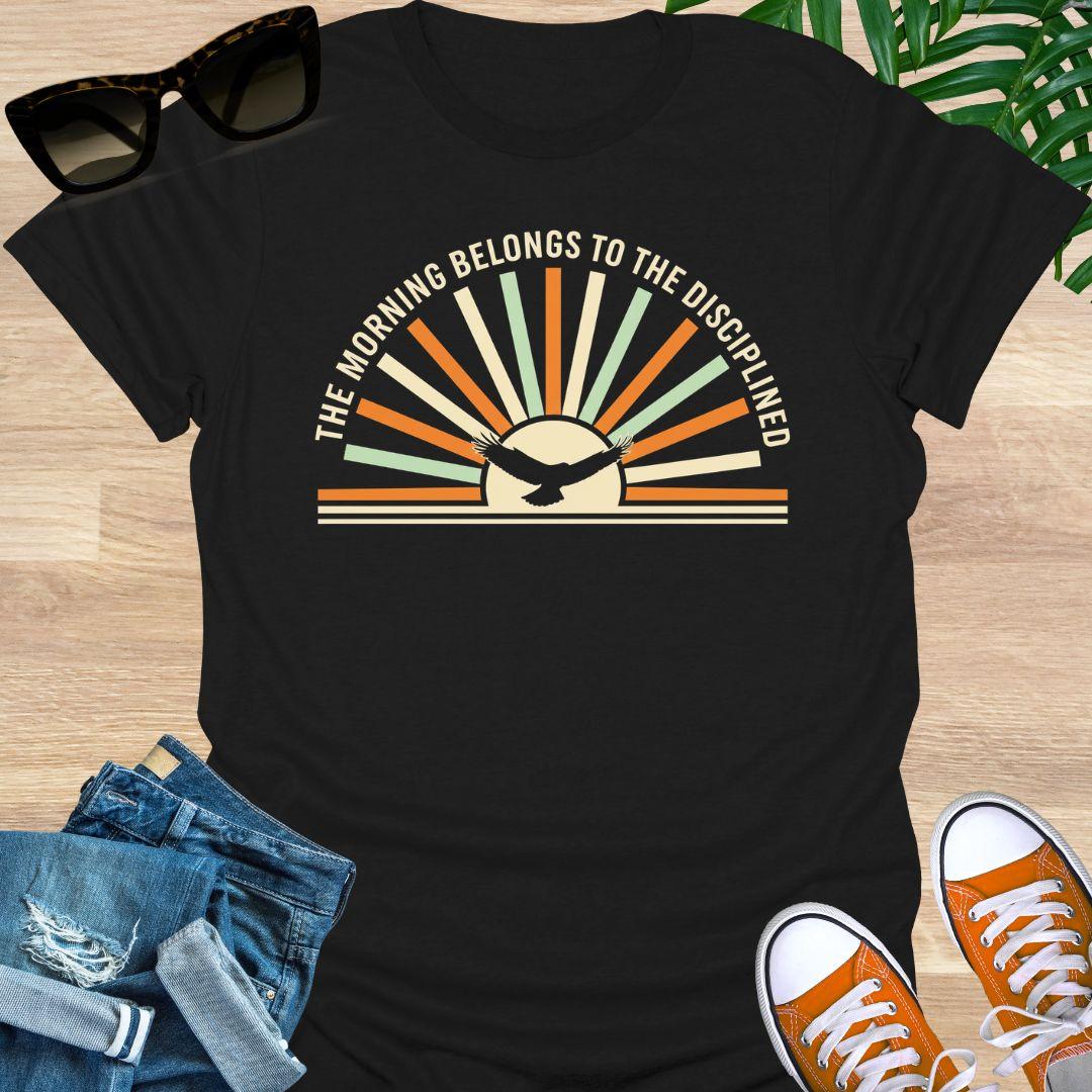 Sunrise with eagle silhouette and Morning Belongs to the Disciplined message symbolizing discipline, focus, growth, and success mindset on a black tee