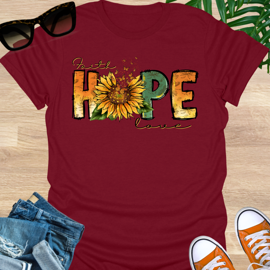 Red t-shirt with a sunflower and monarch butterflies between the words "Faith, Hope, Love" on a unisex graphic tee.