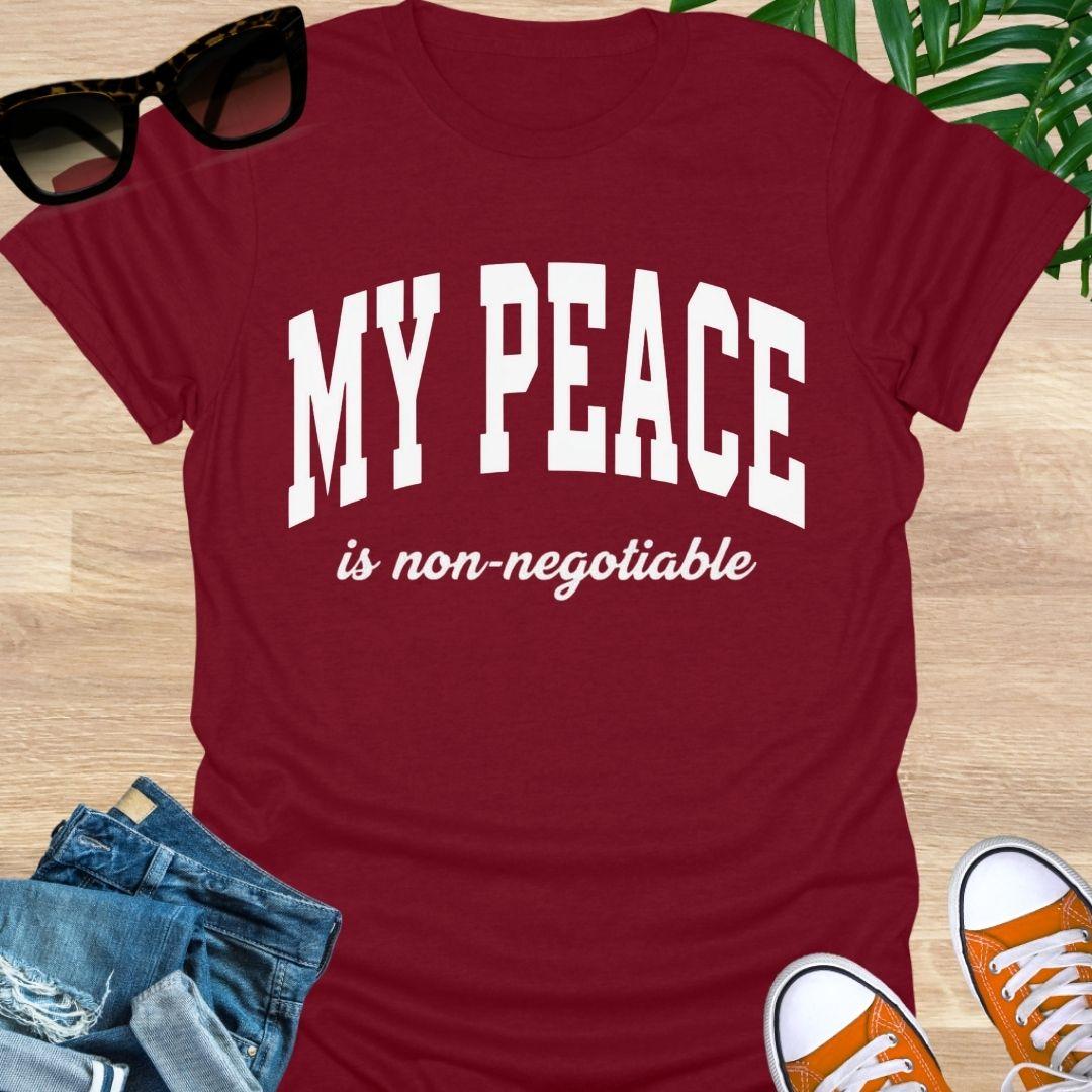 “My Peace Is Non-Negotiable” in white collegiate lettering on a red unisex tee.