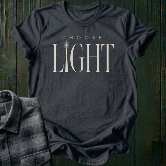 Elegant minimalist typography design featuring the phrase "Choose Light" with a radiant sunbeam replacing the letter I in "Light" on a charcoal tee