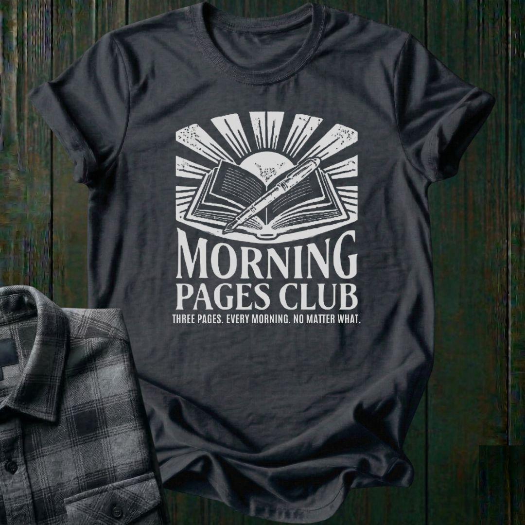 Vintage-style graphic featuring an open journal, pen, and sunrise above the words "Morning Pages Club" with the phrase "Three Pages. Every Morning. No Matter What." on a charcoal tee. 