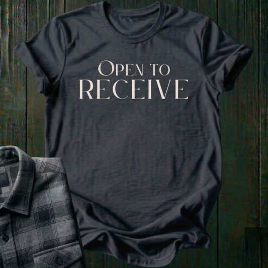 Elegant minimalist typography design featuring the phrase "Open to Receive" in refined serif lettering on a charcoal tee