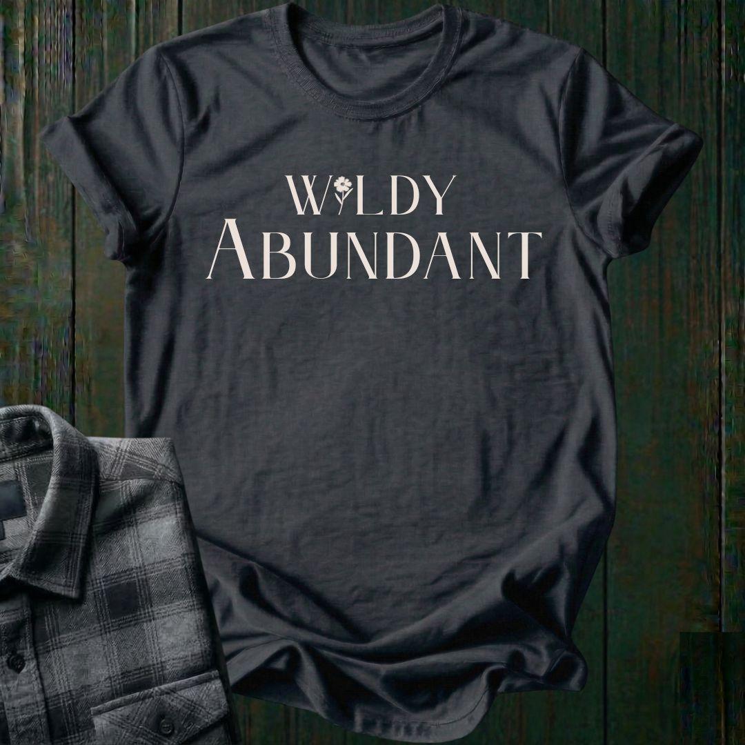 Elegant typography design featuring the phrase "Wildly Abundant" with a flower replacing the letter I in Wildly on a charcoal tee.