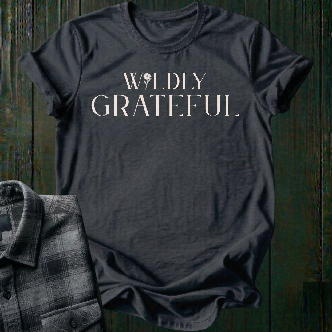 Elegant typography design featuring the phrase "Wildly Grateful" with a flower replacing the letter I in Wildly on a charcoal tee