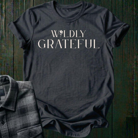 Elegant typography design featuring the phrase "Wildly Grateful" with a flower replacing the letter I in Wildly on a charcoal tee