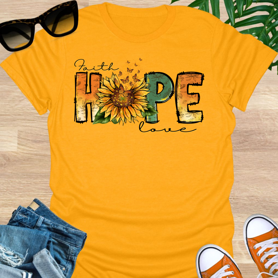 Yellow t-shirt with a sunflower and monarch butterflies between the words "Faith, Hope, Love" on a unisex graphic tee.