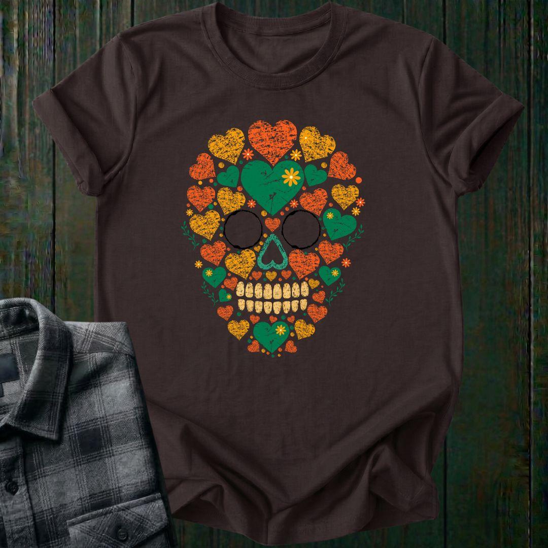 Distressed floral skull graphic made from colorful hearts, flowers, and botanical elements in green, orange, and yellow vintage-style artwork on a dark chocolate tee