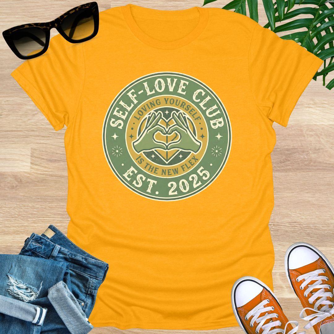 Vintage badge-style design with hands forming a heart and text “Self-Love Club – Loving Yourself Is the New Flex.” on a yellow unisex tee