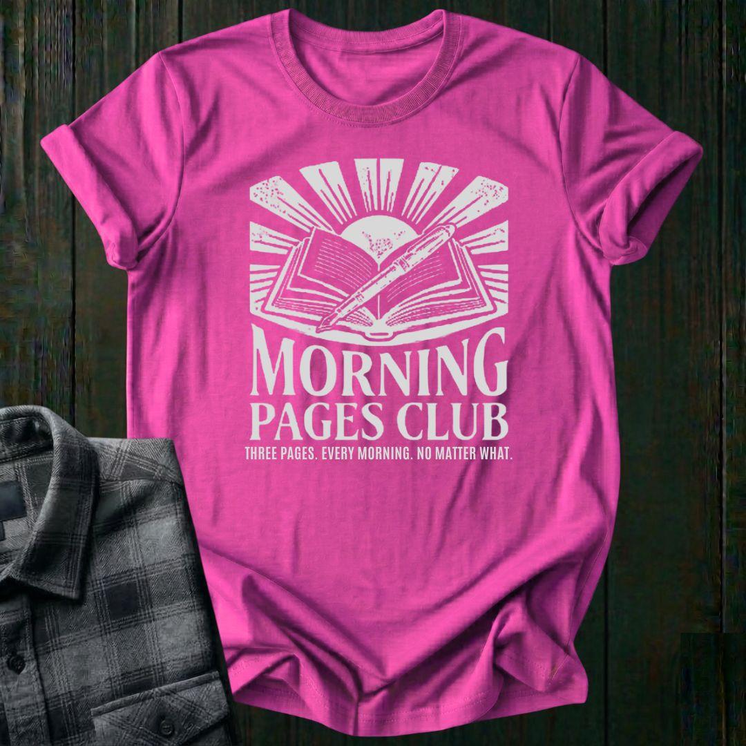 Vintage-style graphic featuring an open journal, pen, and sunrise above the words "Morning Pages Club" with the phrase "Three Pages. Every Morning. No Matter What." on a hot pink tee. 