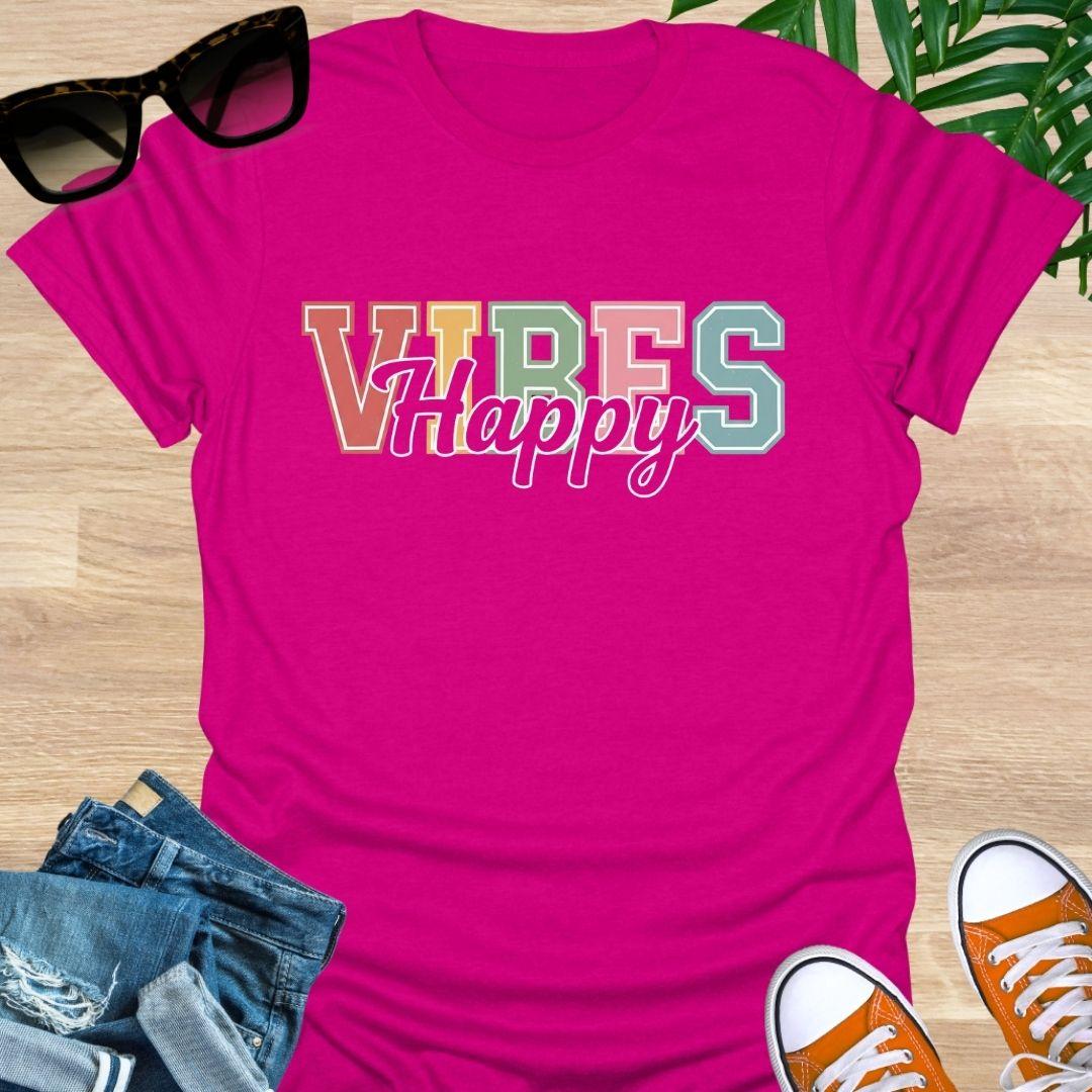 “Happy Vibes” in retro varsity letters with script overlay on a hot pink unisex tee.