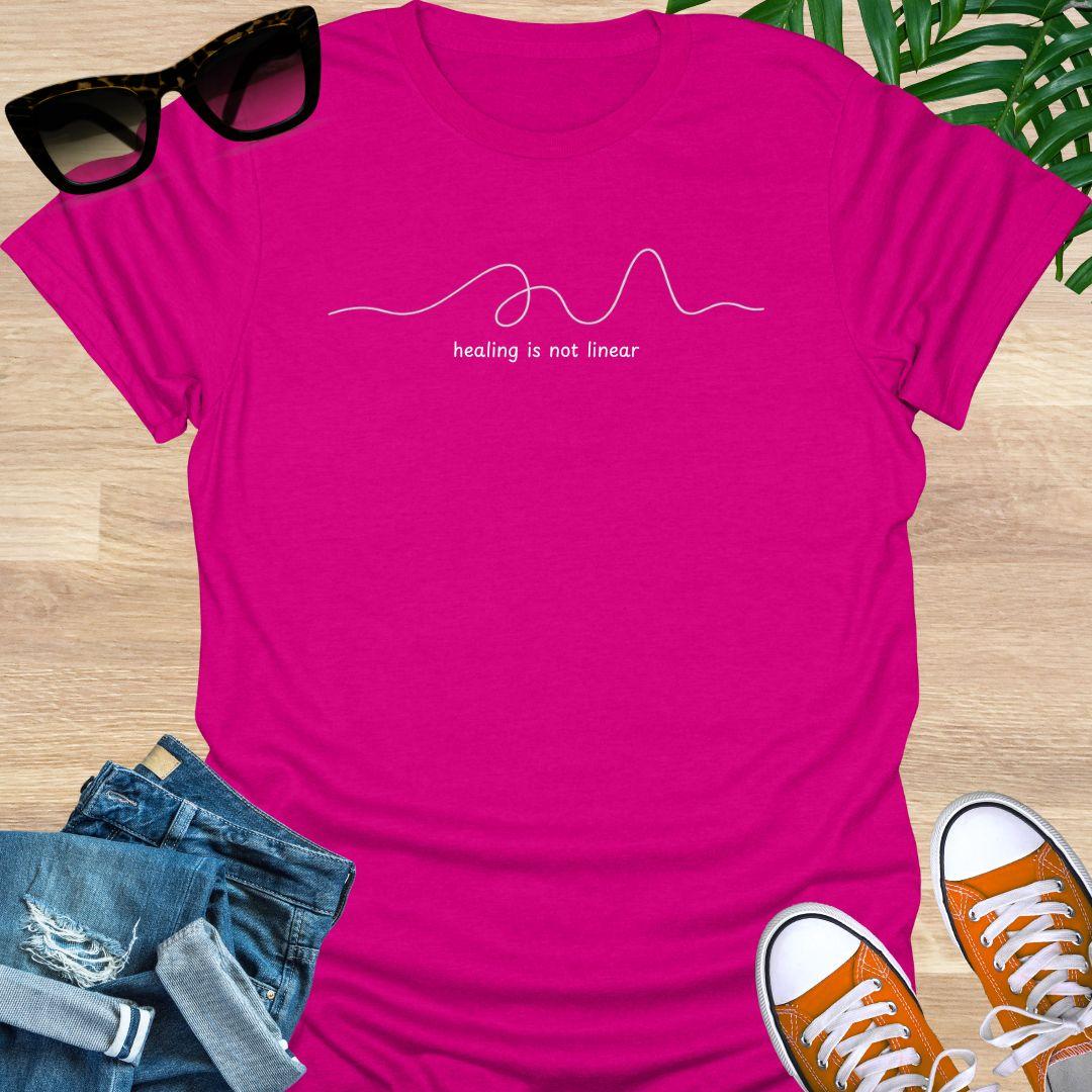 Hot Pink unisex t-shirt with minimalist line art and white text reading healing is not linear