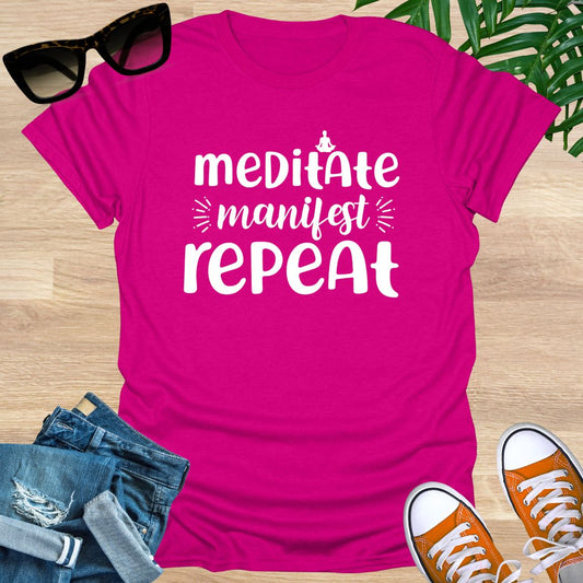 Hot pink unisex t-shirt with white text reading meditate manifest repeat, minimalist mindfulness and manifestation design