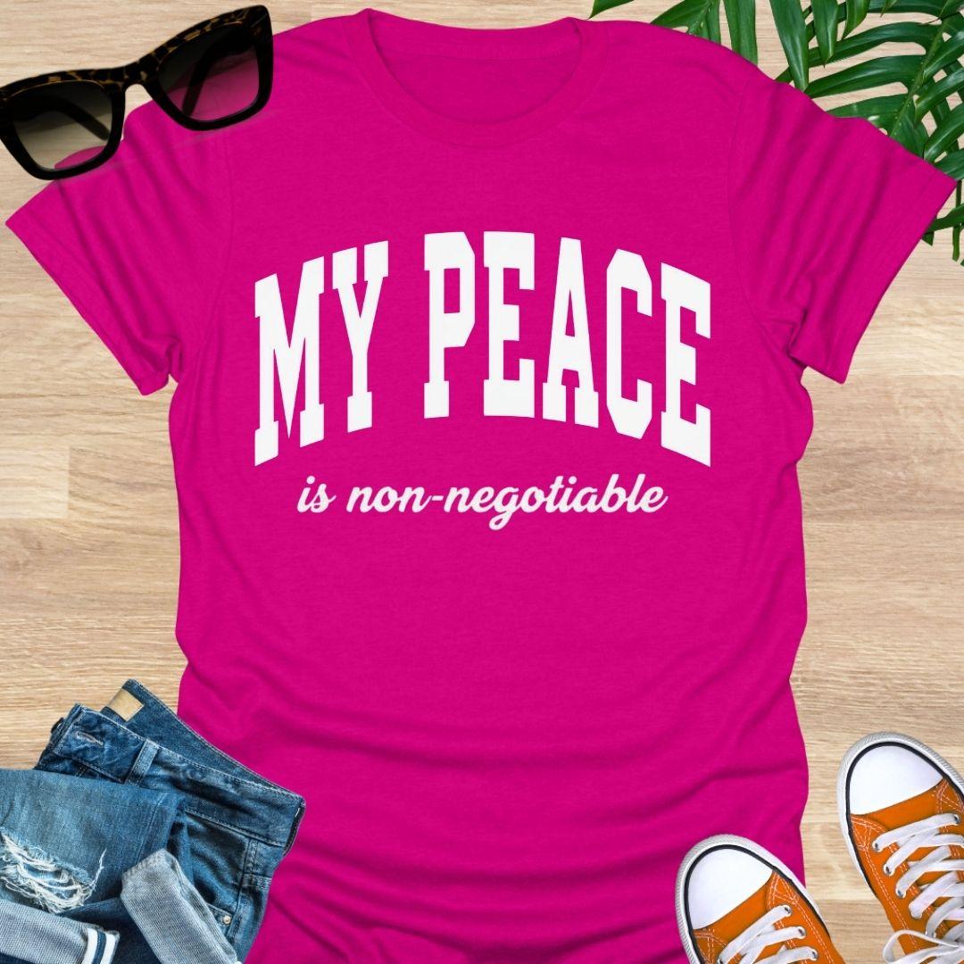 “My Peace Is Non-Negotiable” in white collegiate lettering on a hot pink unisex tee.