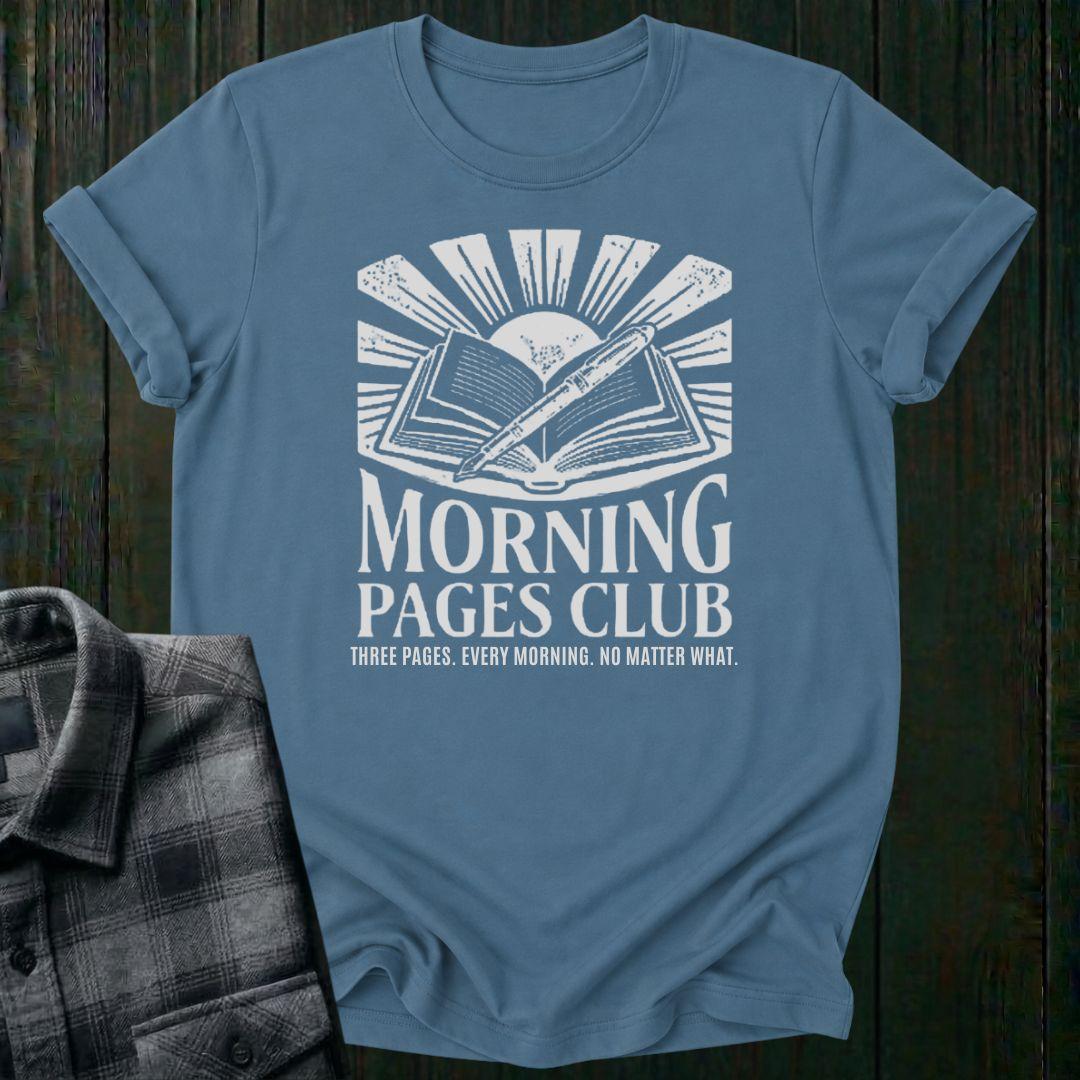 Vintage-style graphic featuring an open journal, pen, and sunrise above the words "Morning Pages Club" with the phrase "Three Pages. Every Morning. No Matter What." on a blue tee. 